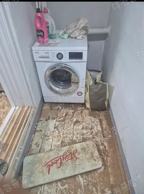 세탁기 옆 토사로 오염된 다용도실 바닥과 매트